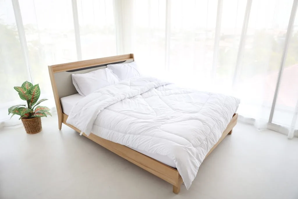 Opgemaakt bed met dekbed en kussens